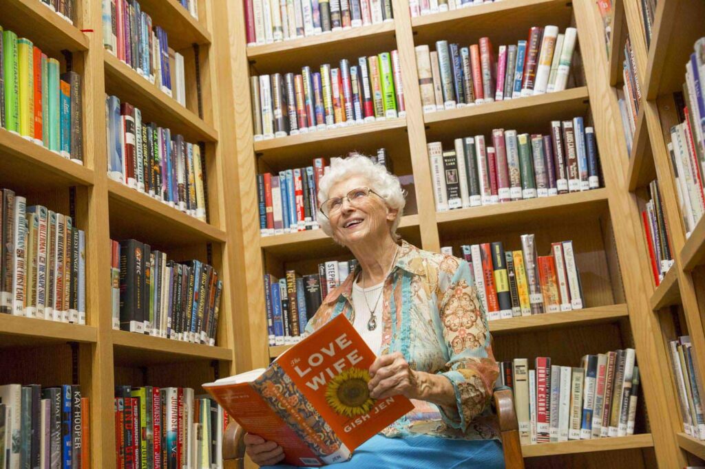 Hillcrest | Senior woman reading in library