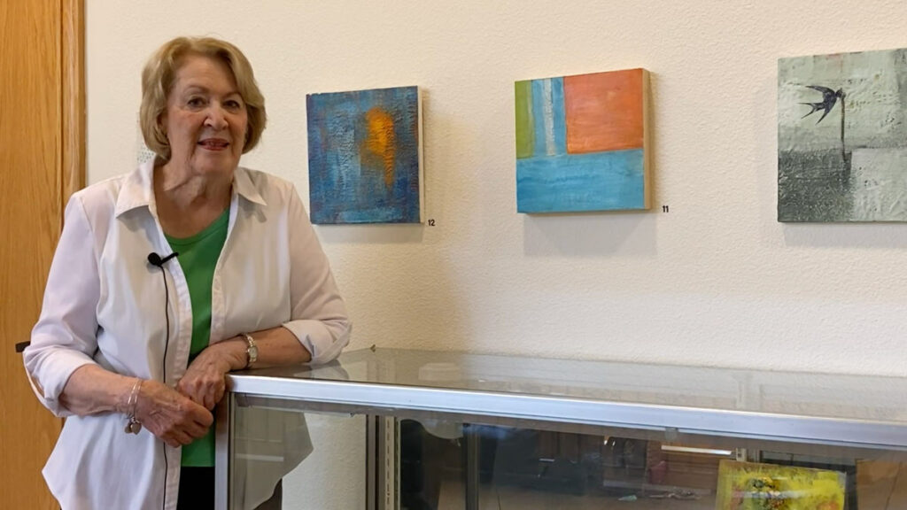 Hillcrest | Senior woman standing next to some artwork