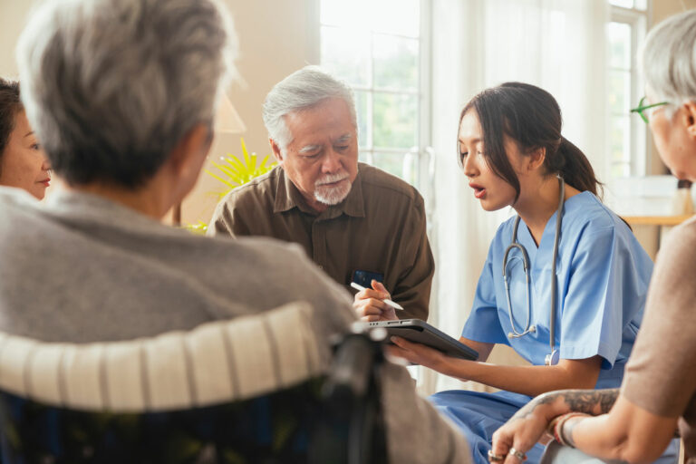 Hillcrest | Group of seniors looking at healthcare professional's tablet