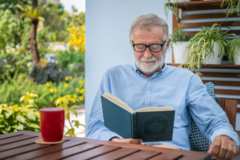 Hillcrest | Senior man reading outdoors