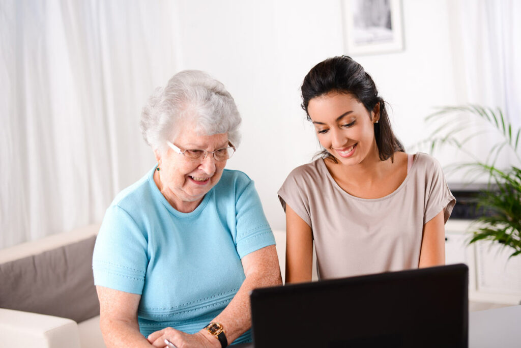 Hillcrest | Senior woman and her caregiver looking at a computer