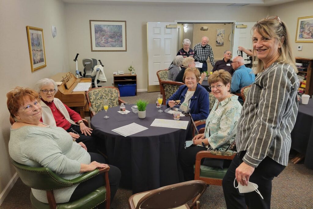 Hillcrest | Assisted living residents sitting around the table having a drink