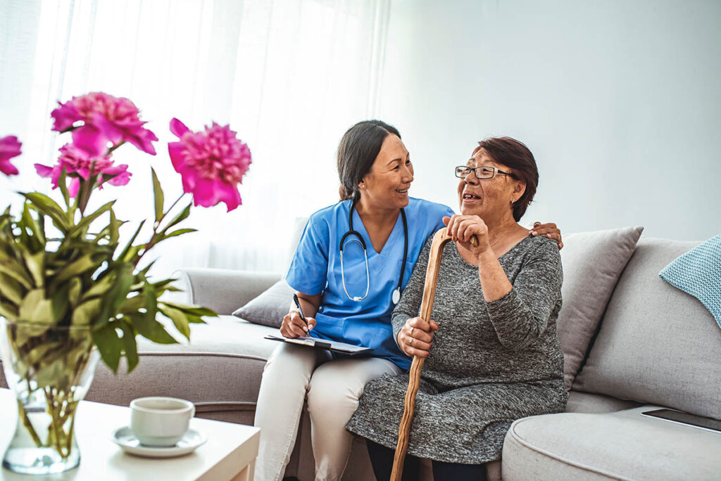 Hillcrest | Senior woman sitting In chair with nurse in retirement home